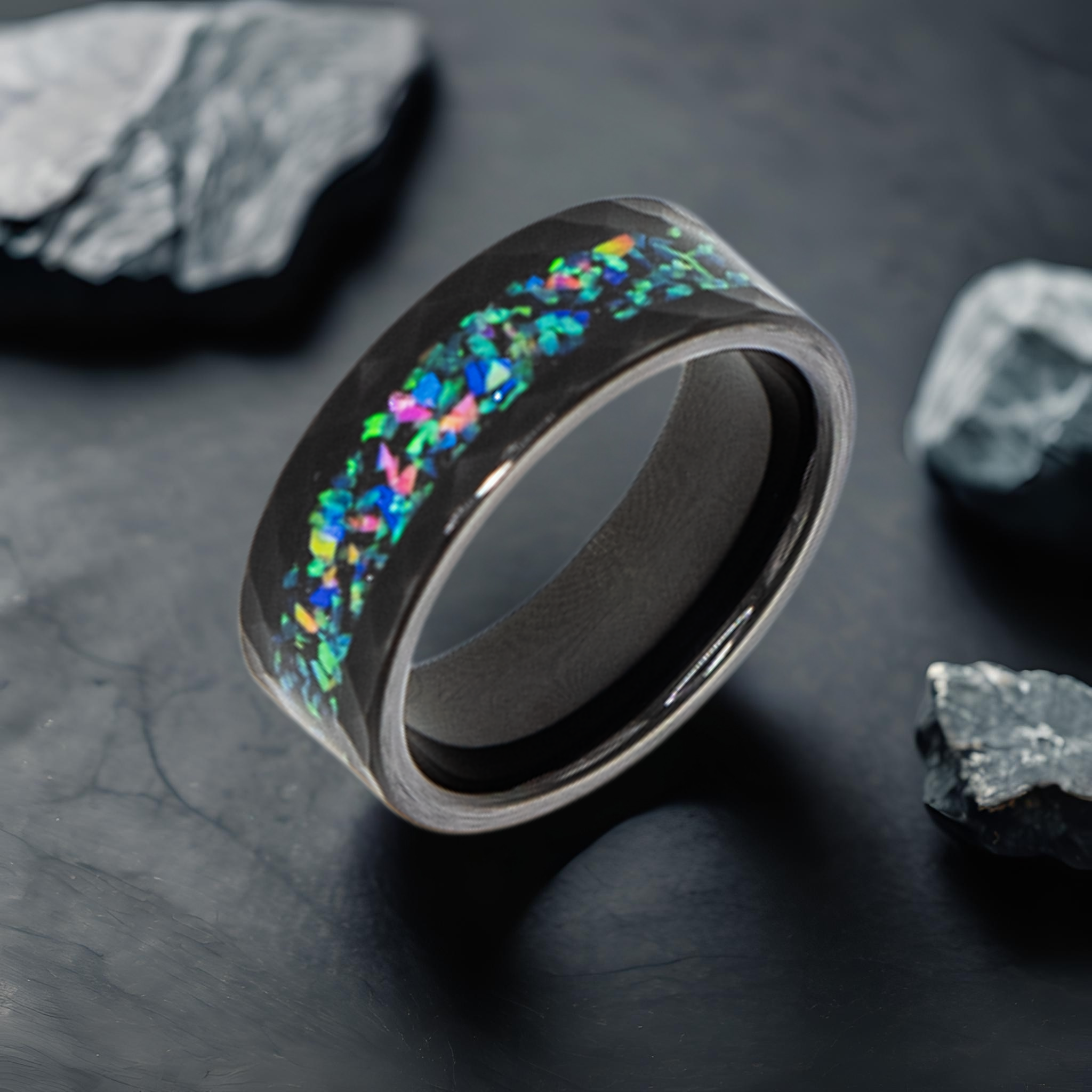 Aeolus ring – Hammered Black Tungsten, Crushed Opal Inlay from the Hustler Collection. Lifestyle shot, placed on textured marble.