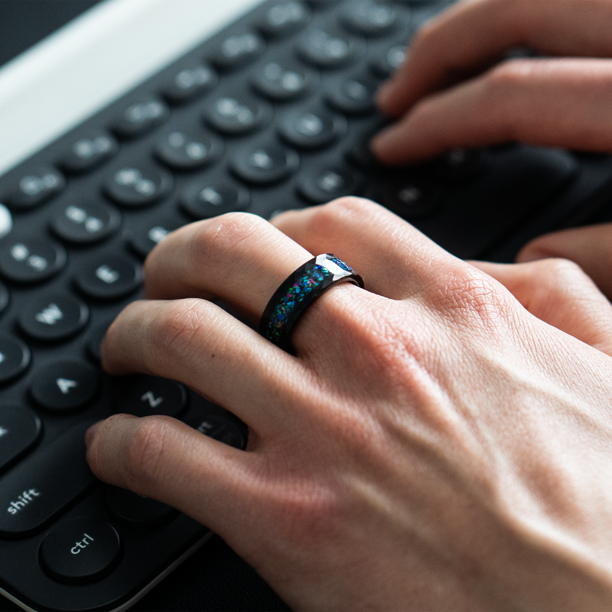 Aeolus ring – Hammered Black Tungsten, Crushed Opal Inlay from the Hustler Collection. Lifestyle Shot, On Hand.