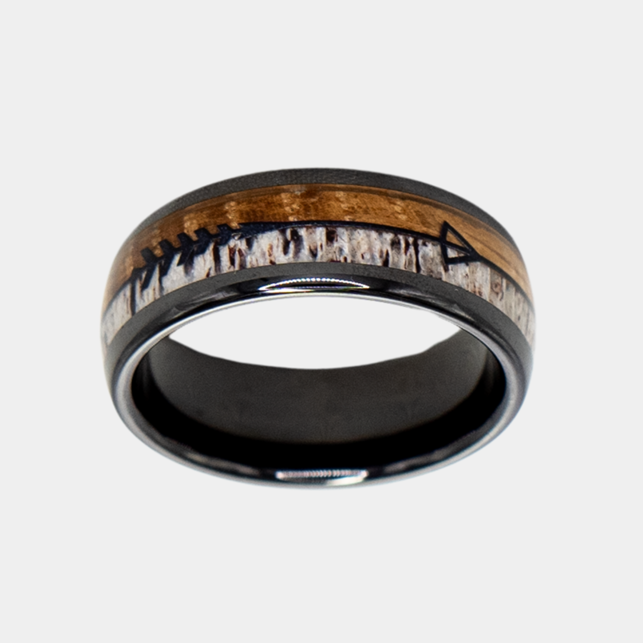Eros ring – polished Black Ceramic featuring Whiskey Barrel Wood, Deer Antler and Black Arrow Foil part of the Hustler Collection. Top-down view showcasing ring face.