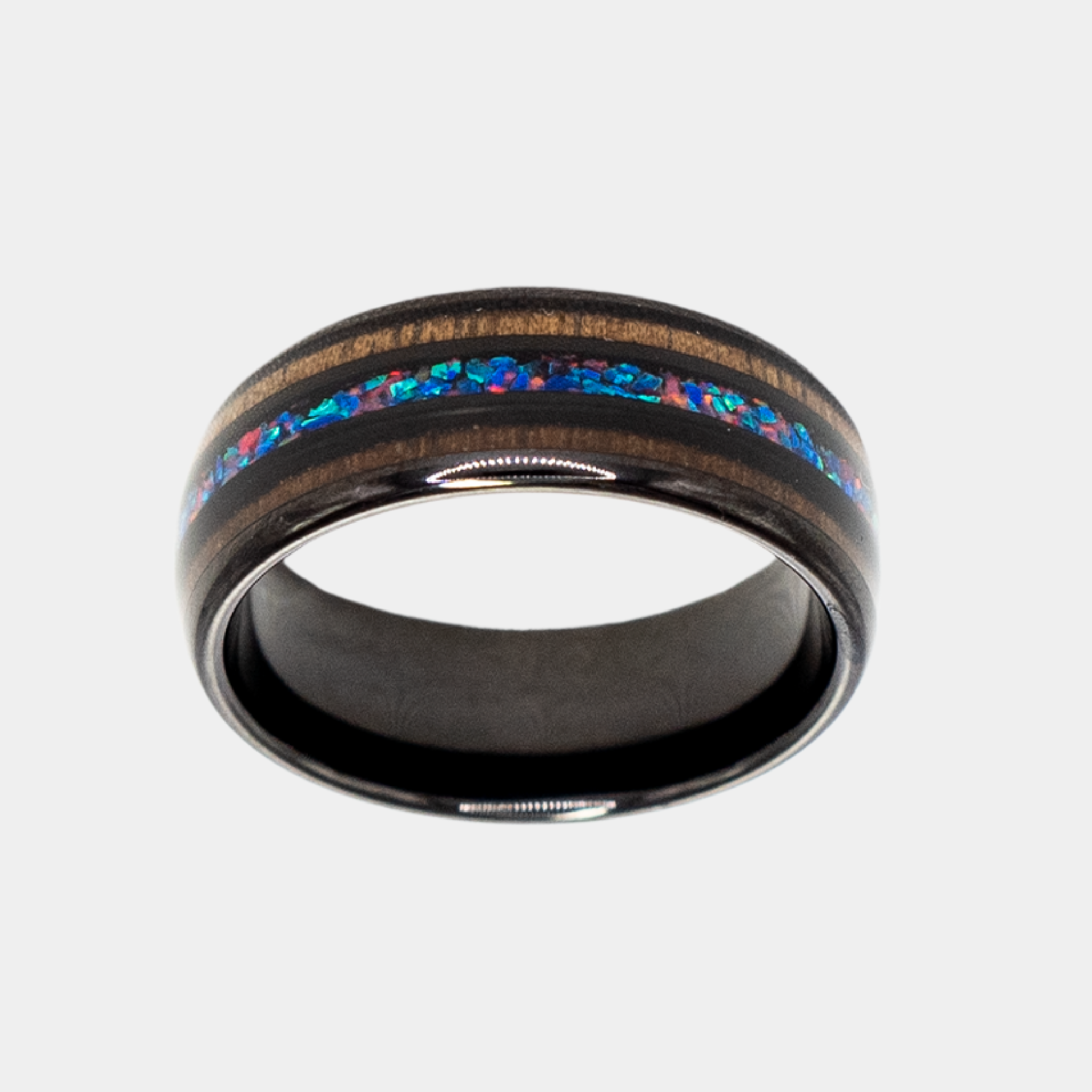 Nereus ring – Black Tungsten featuring Double Koa Wood and Crushed Opal Inlays from the Hustler Collection. Top-down view showcasing ring face.