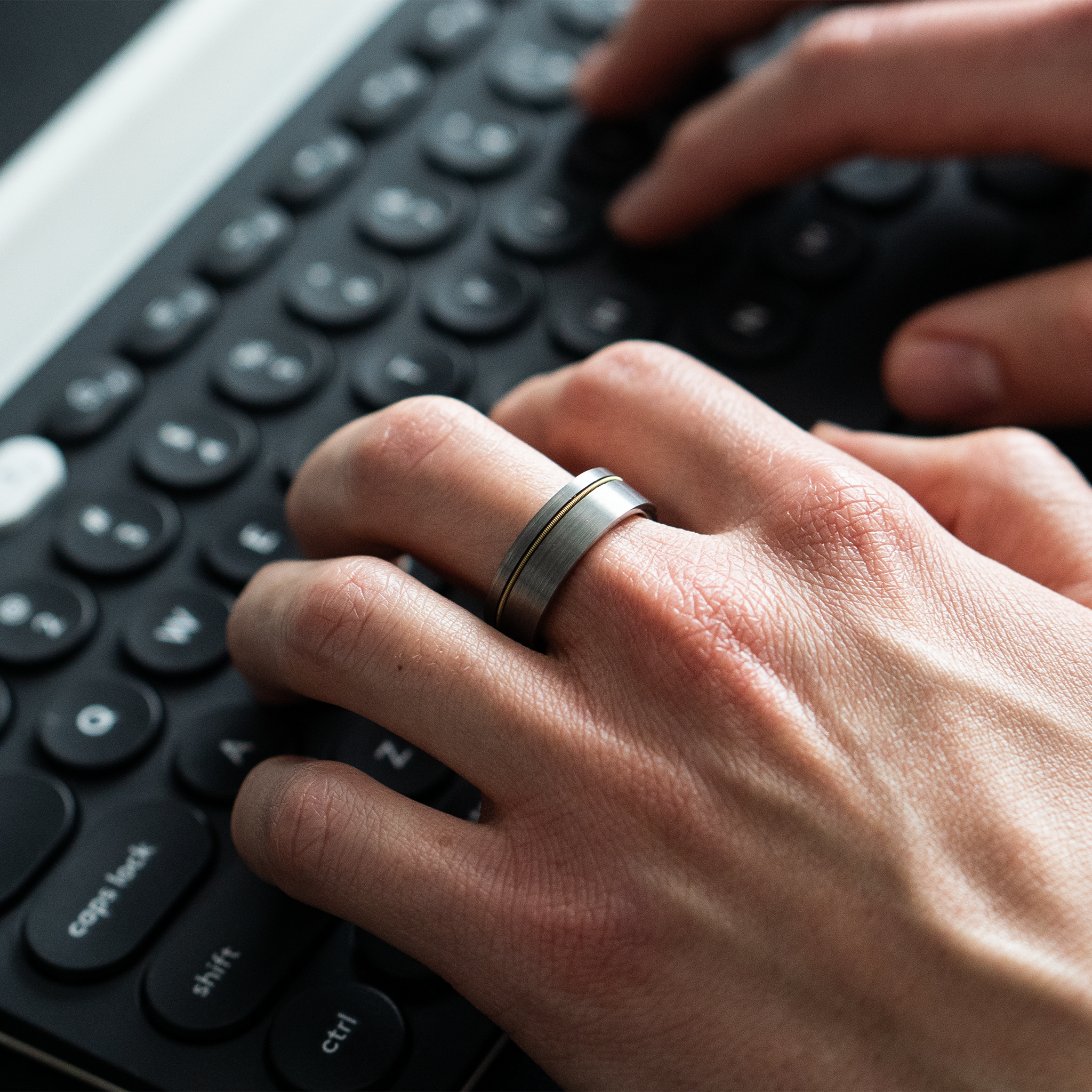 Orpheus ring – Brushed Silver Tungsten with Gold Guitar String Inlay from The Hustler Collection. Lifestyle Shot, On Hand