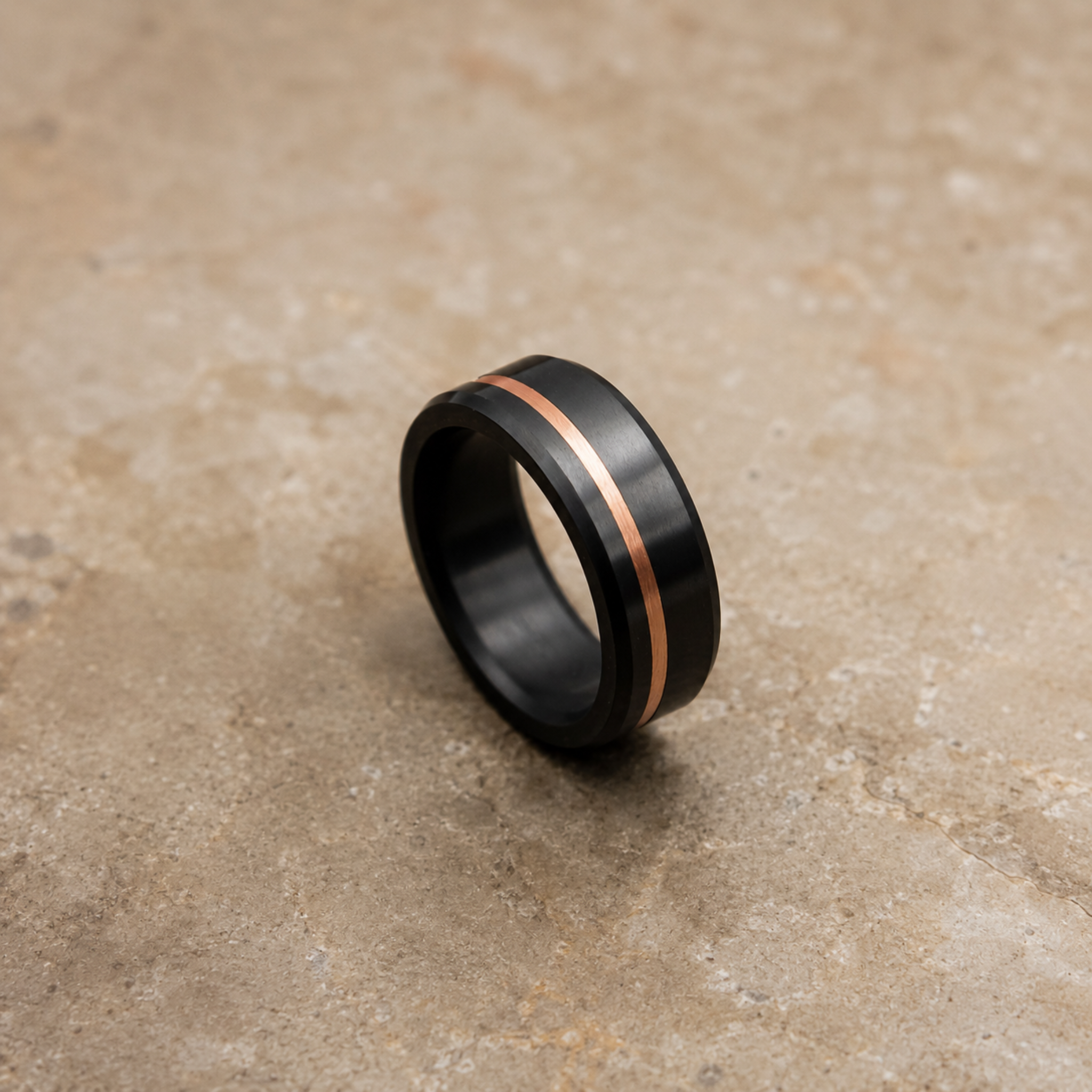 ARES solid black diamond ring with 10K rose gold offset inlay displayed in an editorial setting highlighting the contrast between solid black diamond and rose gold.
