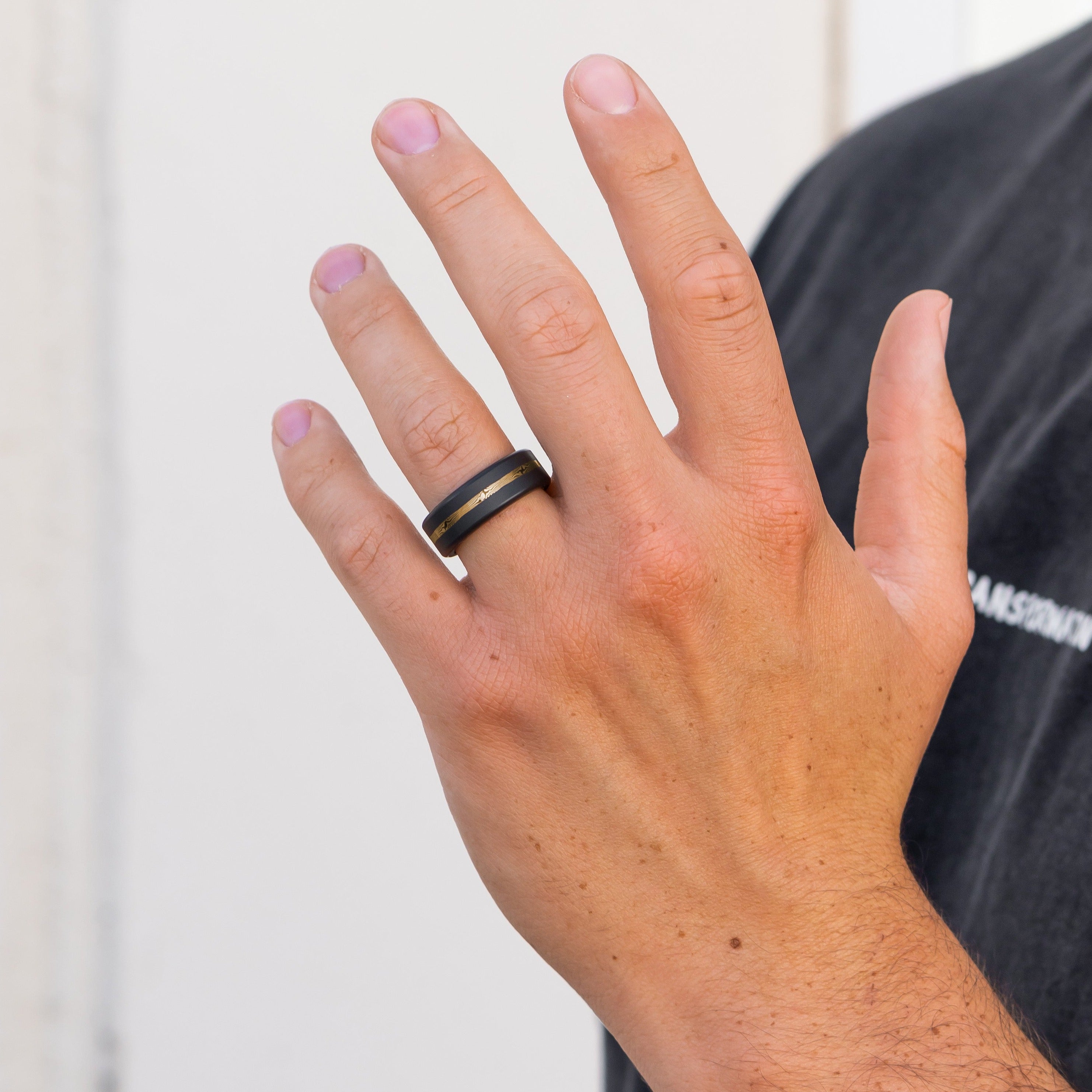 Lifestyle shot #1 of men's hands wearing our Elysium ARES Men's Black Diamond & Mokume 14k Gold Inlay | ElysiumBlack.com | Men’s Mokume Gold Wedding Rings