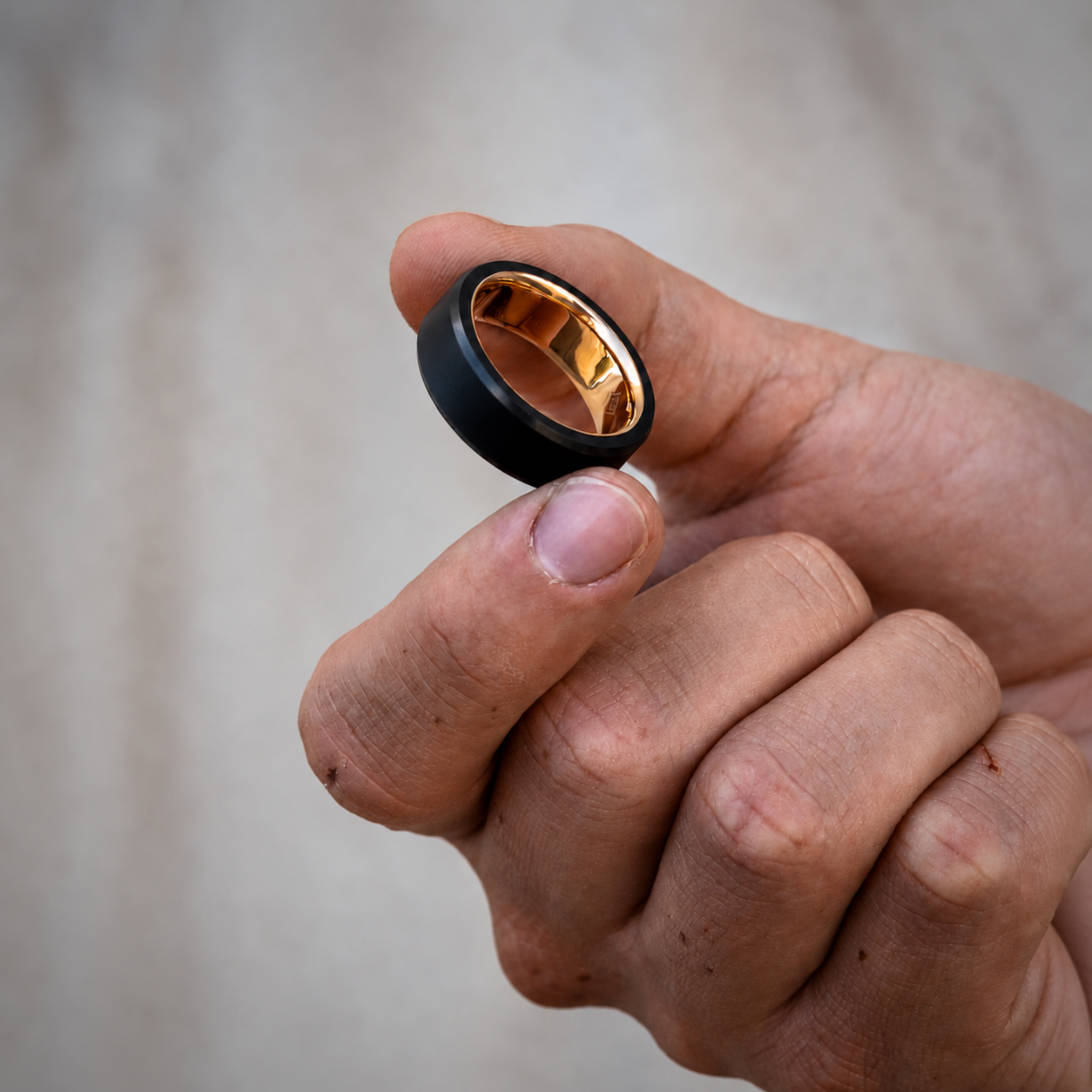 hand holding an ARES 8mm Yellow Gold Sleeve wedding band  