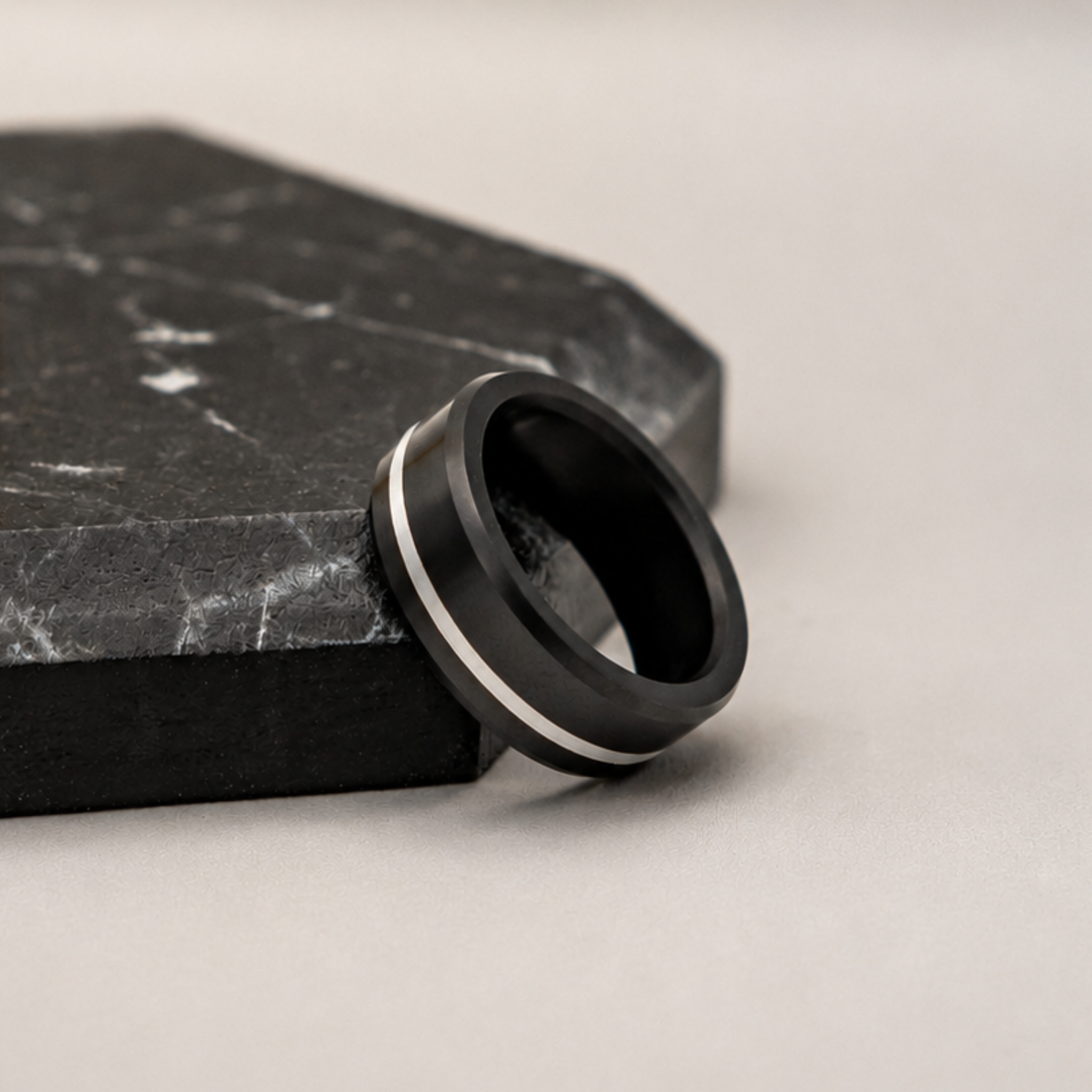 ARES solid black diamond ring with platinum offset inlay displayed in an editorial setting highlighting the contrast between solid black diamond and platinum.