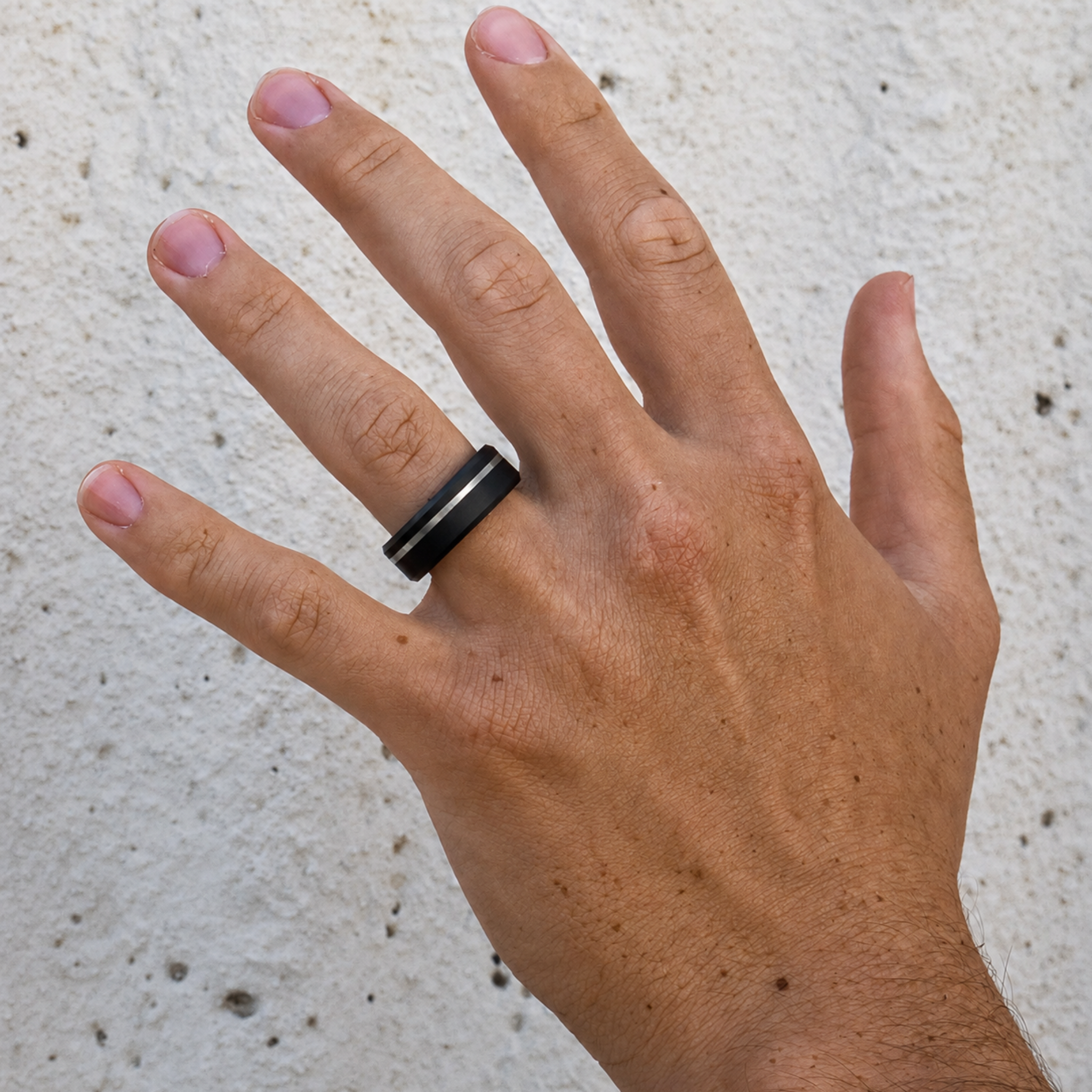 ARES solid black diamond ring with platinum offset inlay worn on hand showing the beveled profile and asymmetric design.