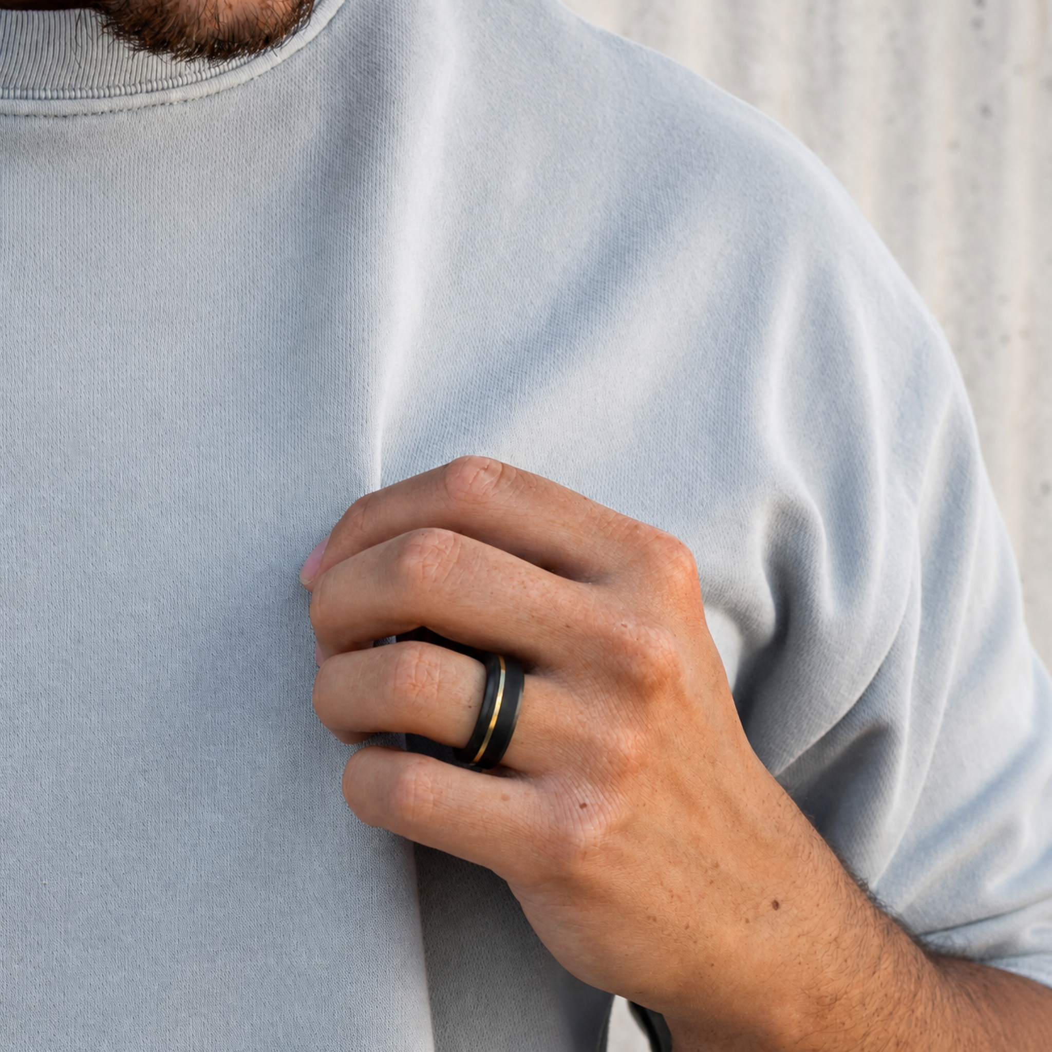 ARES solid black diamond ring with 24K yellow gold offset inlay worn on hand showing the beveled profile and asymmetric design.